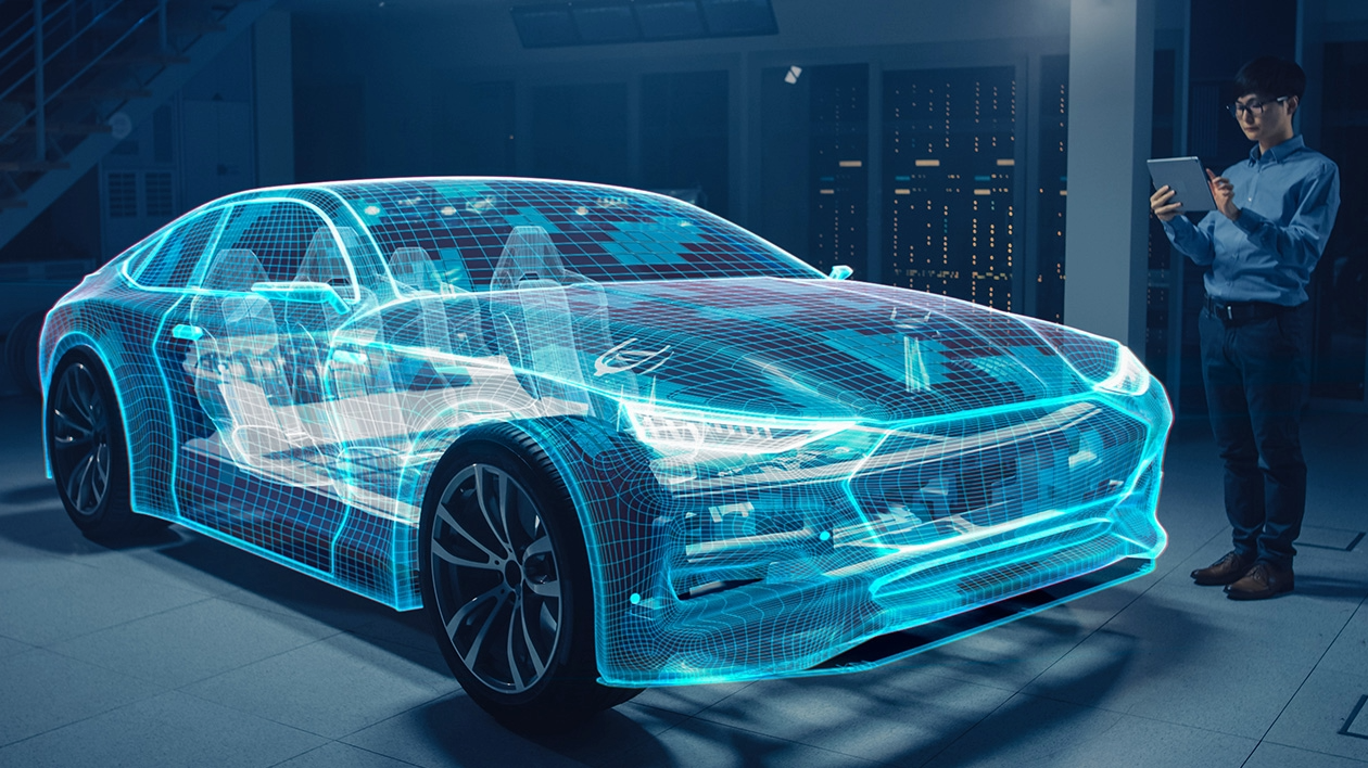 A blue-tinted CGI graphic of a vehicle and its internal systems appear to be glowing in front of a technical designer