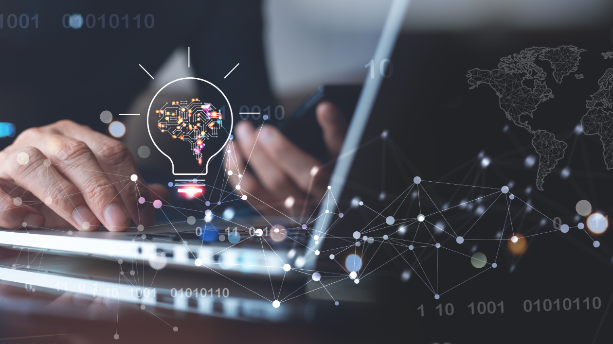 A lightbulb graphic is seen in the foreground with someone typing on a computer and using a mobile device as they work to create solutions to tech problems