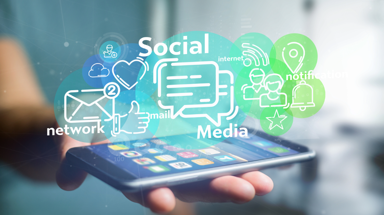 A graphic image of a mobile device illuminating various digital- and social-focused words such as "social" "media" and "network"