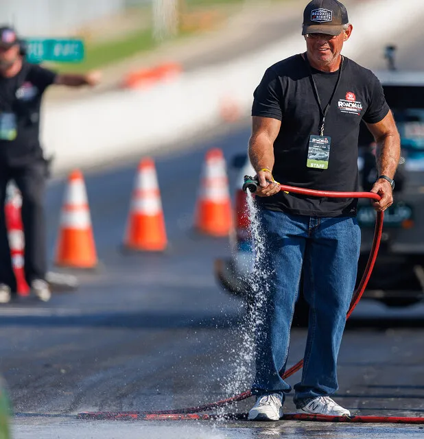 man-watering-drag-strip