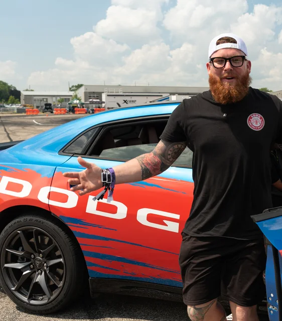 Enthusiast with a blue Dodge performance car