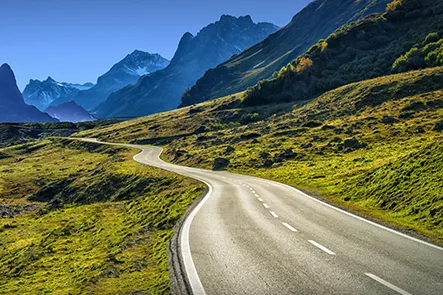Image of a car driver side interior with the road in view. Driving down a road with blur lines.